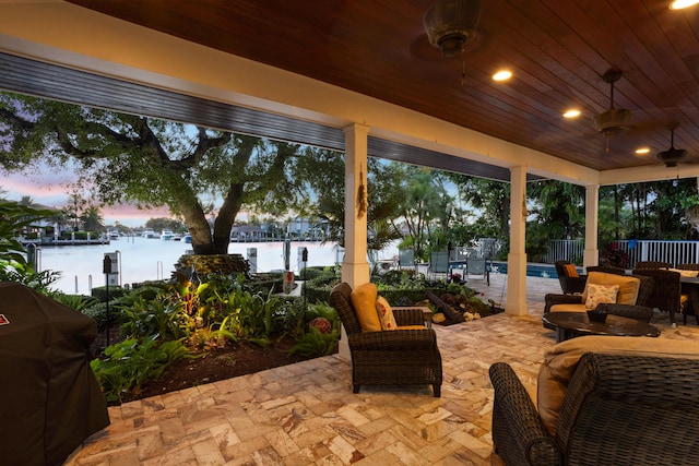 patio terrace at dusk with a water view and grilling area