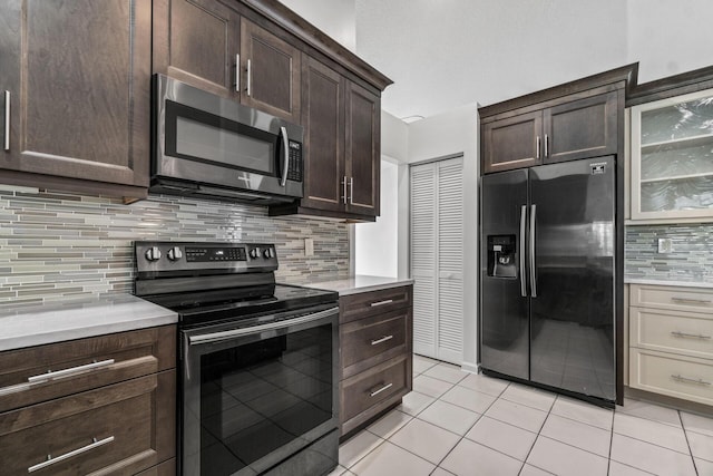 kitchen with tasteful backsplash, light tile patterned flooring, stainless steel appliances, and cream cabinets