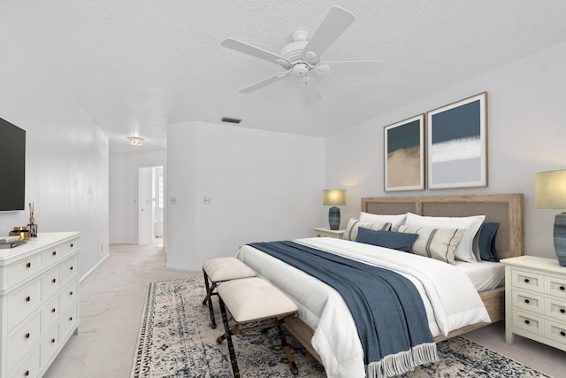 carpeted bedroom with a textured ceiling and ceiling fan