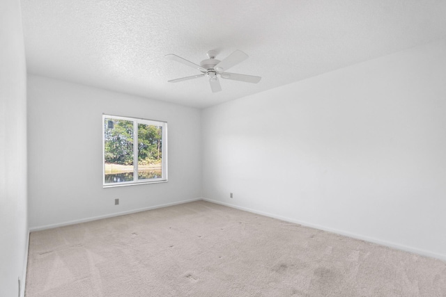 carpeted empty room with ceiling fan and a textured ceiling