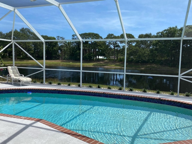 view of pool with a lanai and a water view