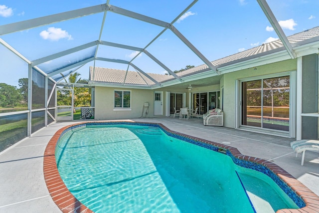 view of swimming pool featuring ceiling fan, a lanai, and a patio