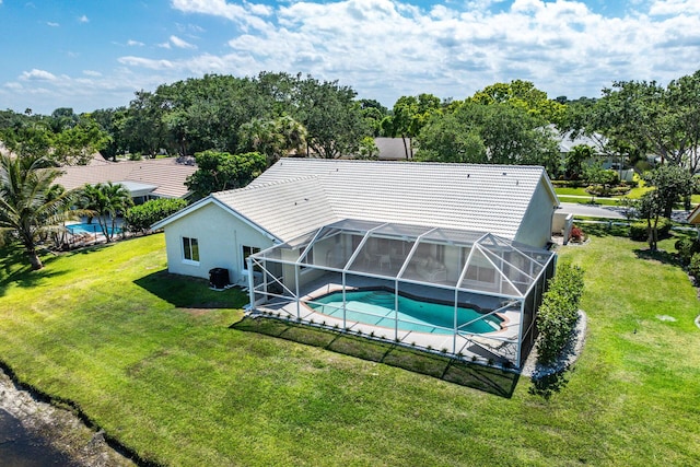 rear view of house with a lanai and a yard