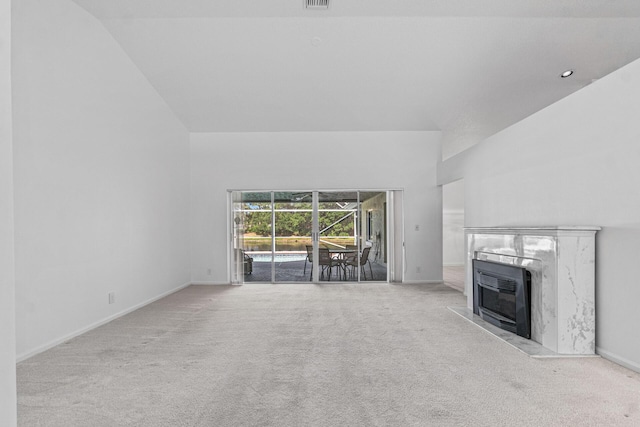 unfurnished living room with light carpet, a fireplace, and high vaulted ceiling