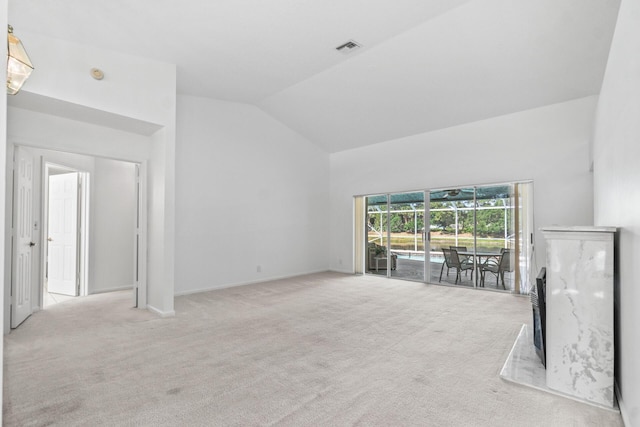 unfurnished living room featuring light carpet and high vaulted ceiling