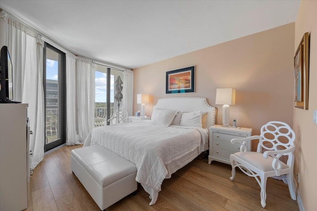 bedroom with wood-type flooring and access to outside