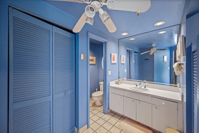 bathroom featuring toilet, tile floors, ceiling fan, and large vanity