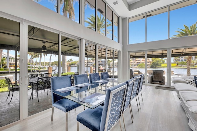 sunroom featuring a water view