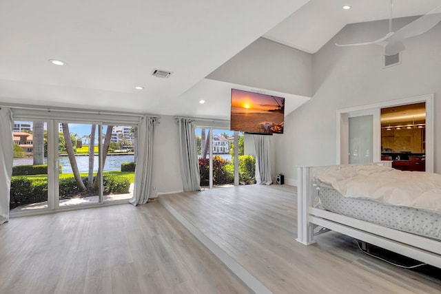 unfurnished bedroom featuring access to exterior, light hardwood / wood-style flooring, and a high ceiling