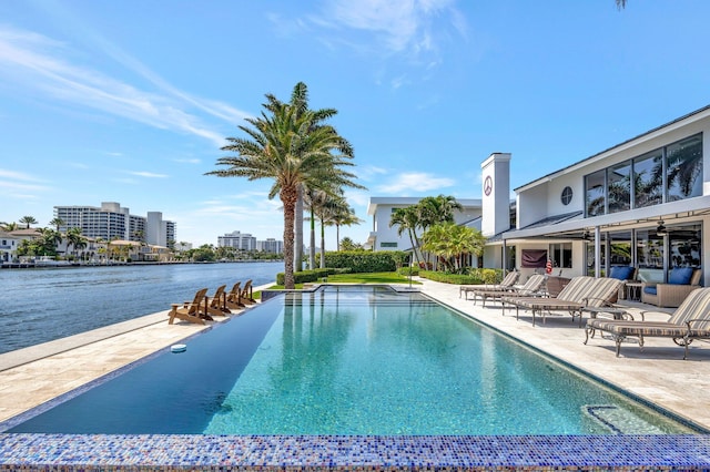 view of pool with a water view and a patio