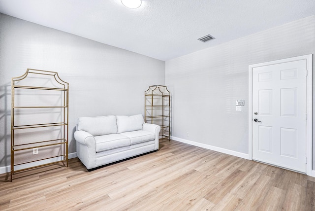 unfurnished room with light hardwood / wood-style floors and a textured ceiling