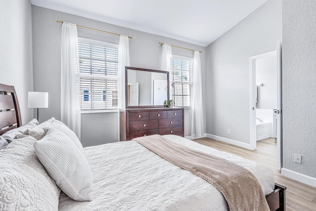 bedroom featuring light hardwood / wood-style flooring, vaulted ceiling, and multiple windows