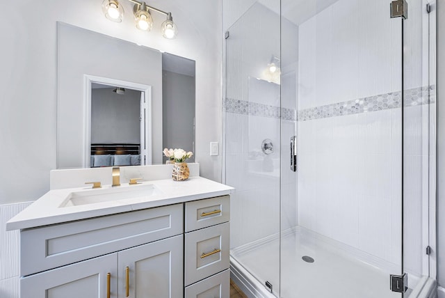 bathroom featuring a shower with door and vanity