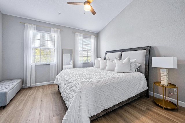 bedroom with hardwood / wood-style floors, lofted ceiling, and ceiling fan