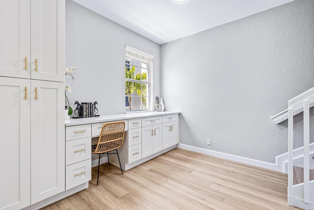 office space with light hardwood / wood-style flooring and built in desk