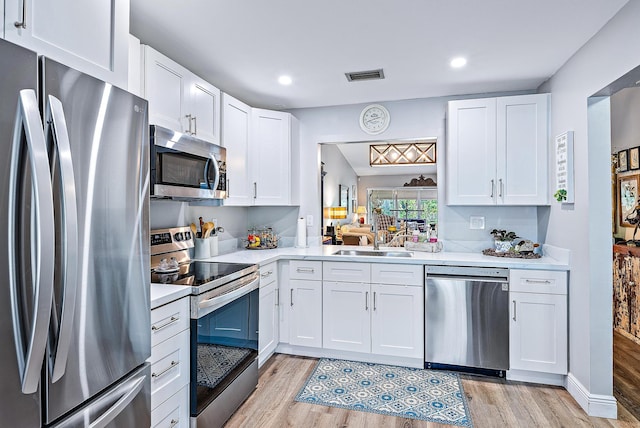 kitchen featuring sink, stainless steel appliances, light wood-type flooring, and white cabinetry