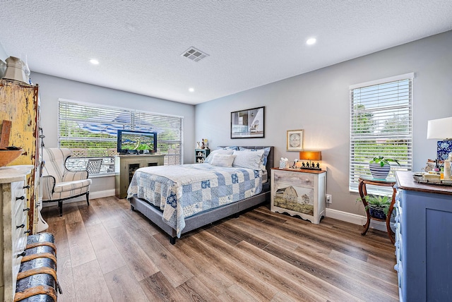 bedroom with a textured ceiling and dark hardwood / wood-style flooring