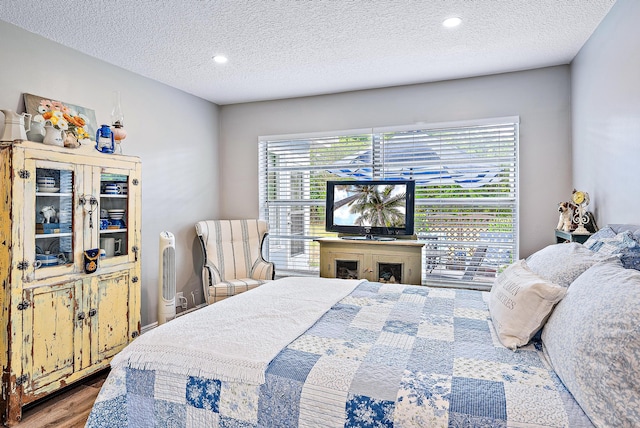 bedroom featuring hardwood / wood-style flooring and a textured ceiling