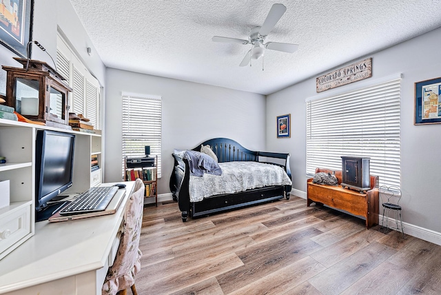 bedroom featuring wood-type flooring, ceiling fan, and a textured ceiling