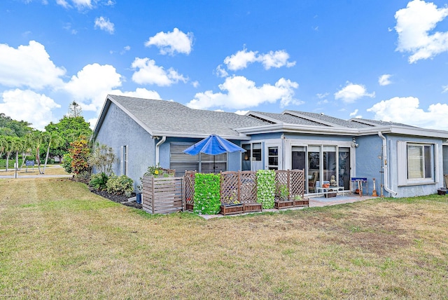 rear view of property featuring a patio and a lawn