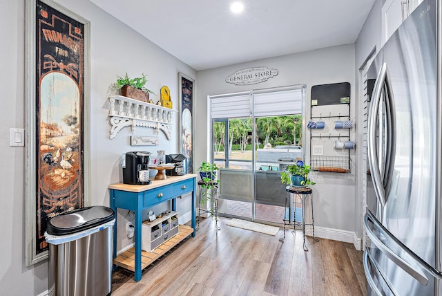 interior space featuring stainless steel refrigerator, wood-type flooring, and blue cabinetry