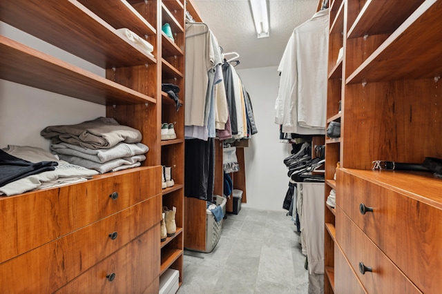 walk in closet with light tile floors