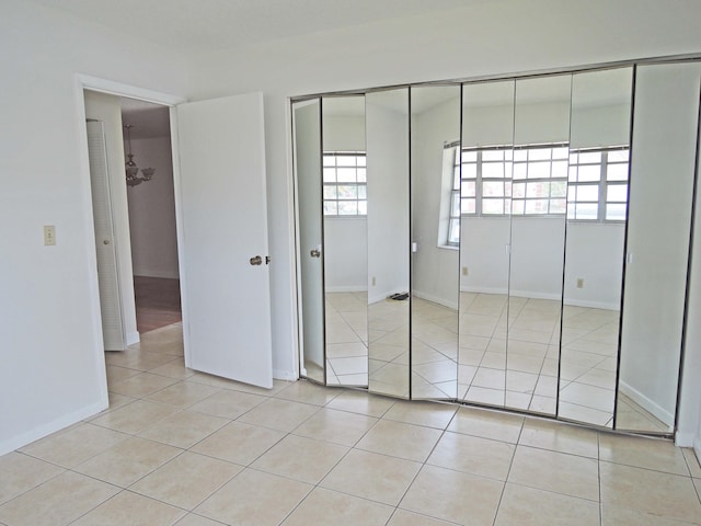 unfurnished bedroom with a closet and light tile flooring