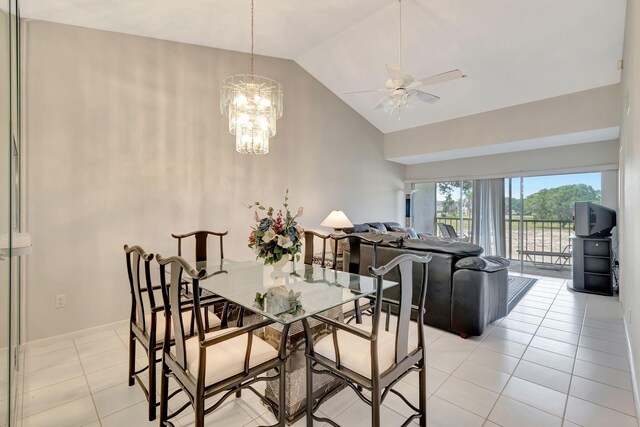 dining space featuring light tile patterned floors, ceiling fan with notable chandelier, and high vaulted ceiling