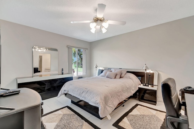 bedroom with ceiling fan, light tile patterned flooring, and a textured ceiling