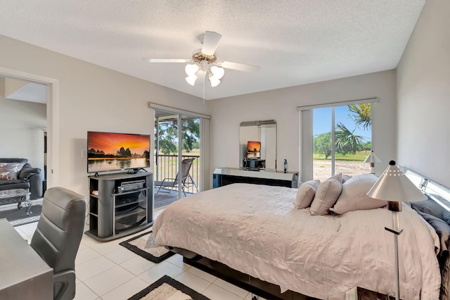 bedroom with access to exterior, ceiling fan, light tile patterned floors, and a textured ceiling