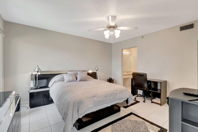 bedroom featuring ceiling fan, light tile patterned flooring, a textured ceiling, and connected bathroom