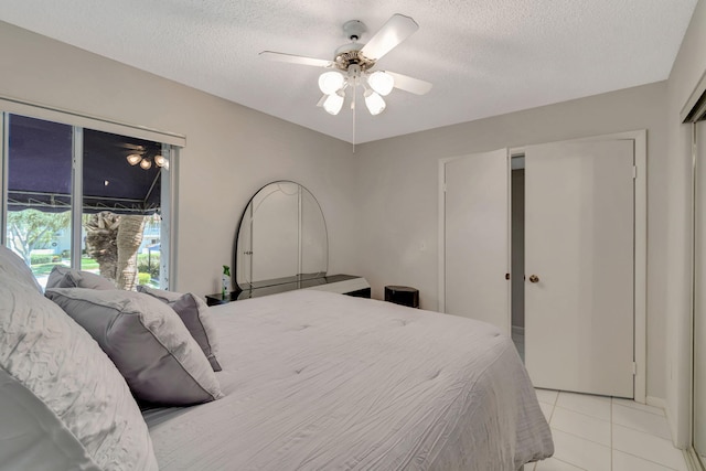 tiled bedroom featuring ceiling fan and a textured ceiling