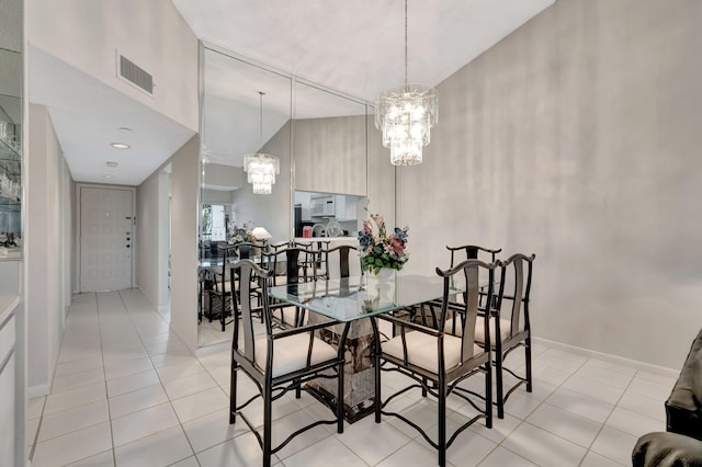 tiled dining room with a towering ceiling and an inviting chandelier