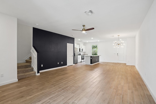 unfurnished living room featuring ceiling fan with notable chandelier, light hardwood / wood-style flooring, and sink