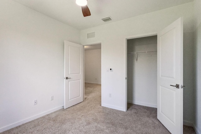 unfurnished bedroom featuring ceiling fan, a closet, and light carpet