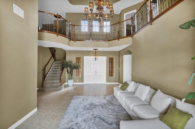 tiled living room featuring a high ceiling and a notable chandelier