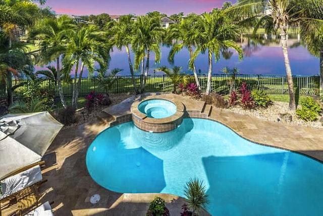 pool at dusk with an in ground hot tub