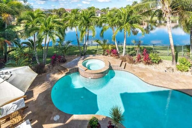 view of swimming pool featuring an in ground hot tub and a water view