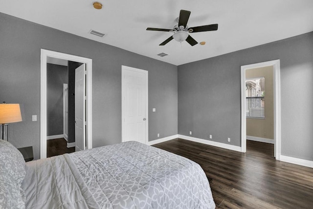 bedroom with ensuite bath, ceiling fan, and dark hardwood / wood-style flooring