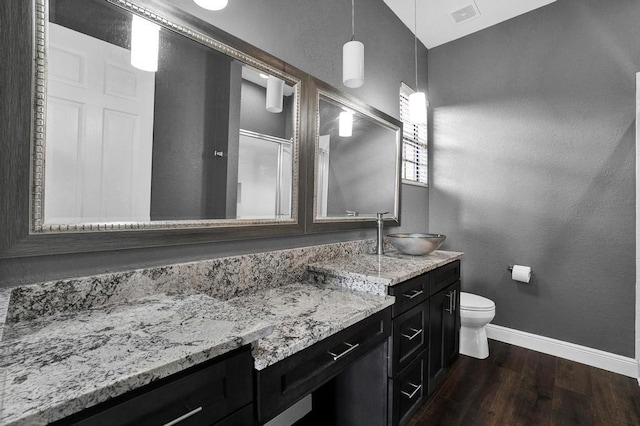 bathroom with hardwood / wood-style flooring, vanity, toilet, and walk in shower