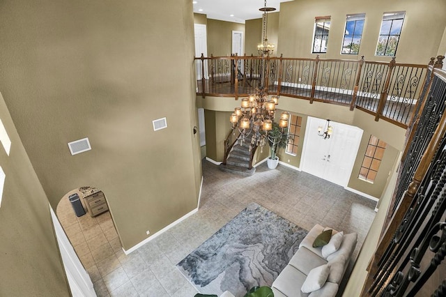 foyer entrance featuring a towering ceiling and an inviting chandelier