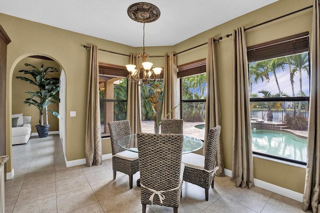 dining area with light tile patterned floors and a chandelier