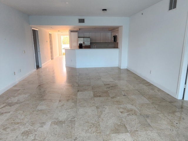 unfurnished living room with sink and light tile floors