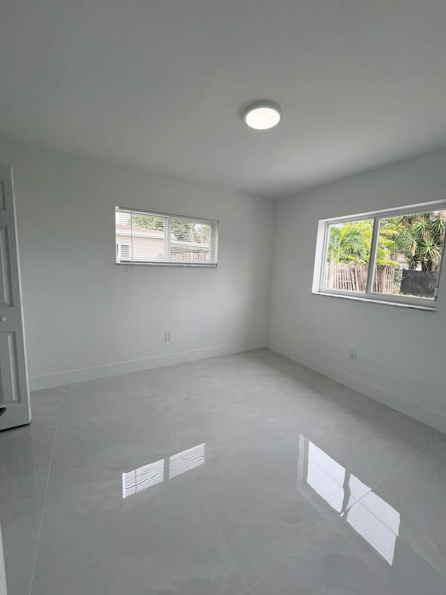 tiled empty room with a healthy amount of sunlight