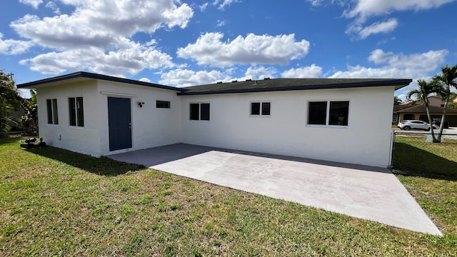 rear view of property with a yard and a patio area