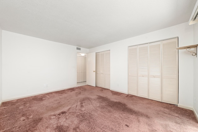 unfurnished bedroom featuring multiple closets and carpet floors