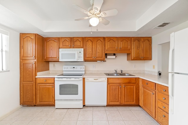 kitchen with ceiling fan, light tile floors, sink, white appliances, and a tray ceiling