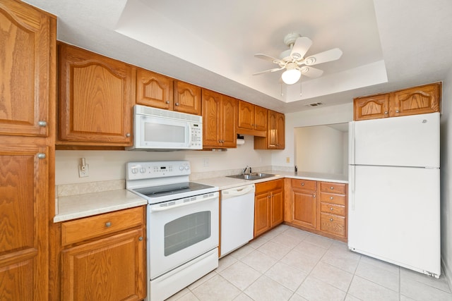 kitchen with ceiling fan, light tile floors, sink, white appliances, and a raised ceiling