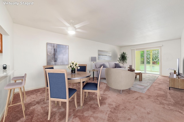 carpeted dining area with ceiling fan