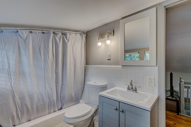 full bathroom featuring vanity, shower / bath combination with curtain, hardwood / wood-style flooring, toilet, and tile walls